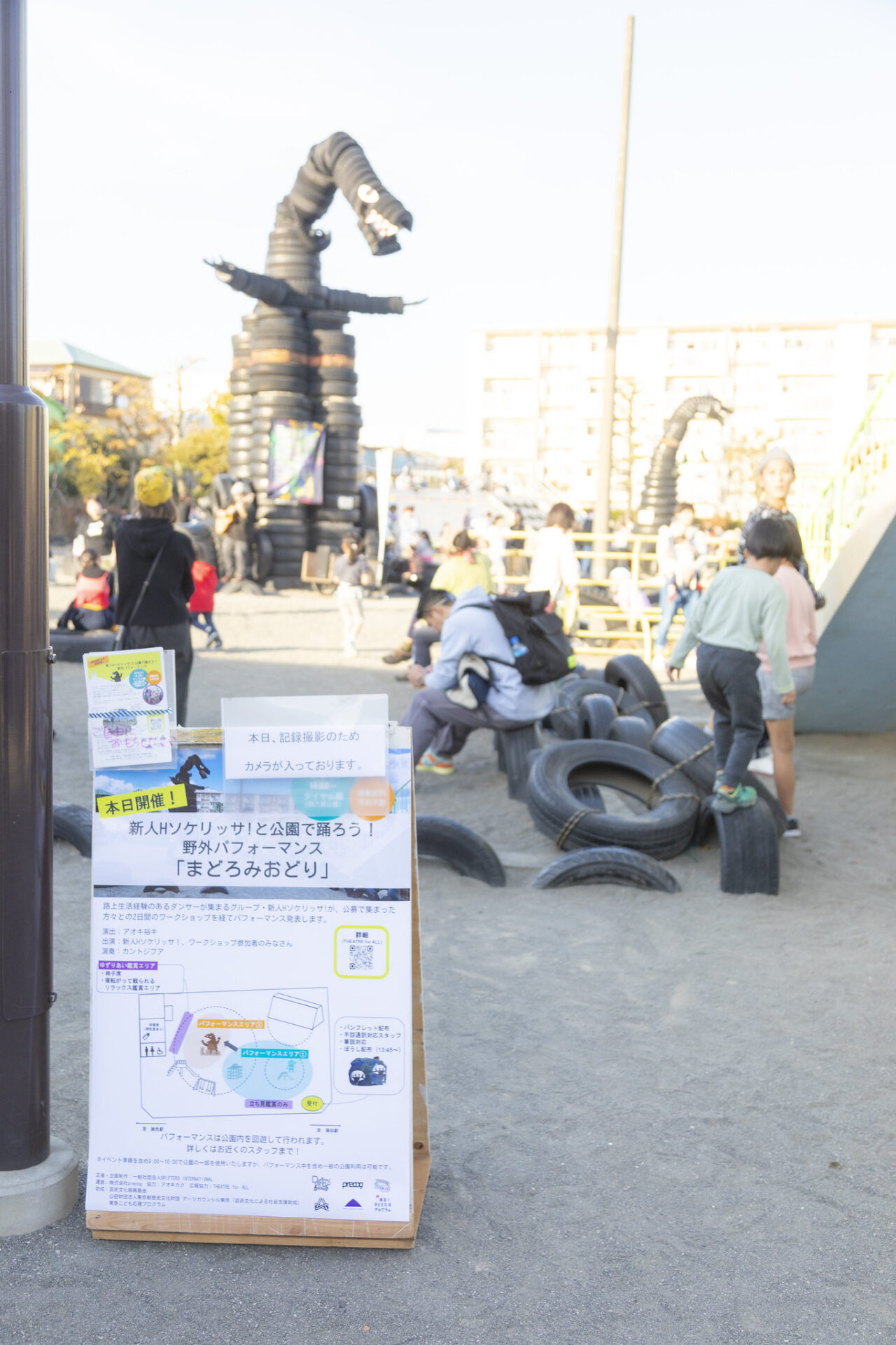 公園入り口には本日の看板。円形にはタイヤで作られた怪獣、遊具で遊ぶ子供たち