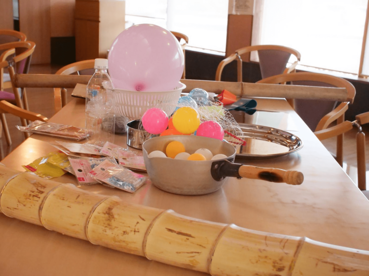 ワークショップに使われる道具が机の上に並ぶ。風船、お鍋、竹の筒など